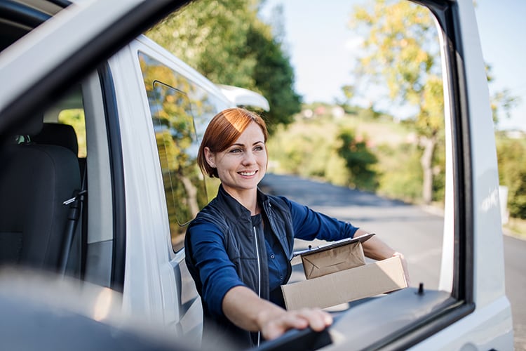A delivery driver holding parcels.